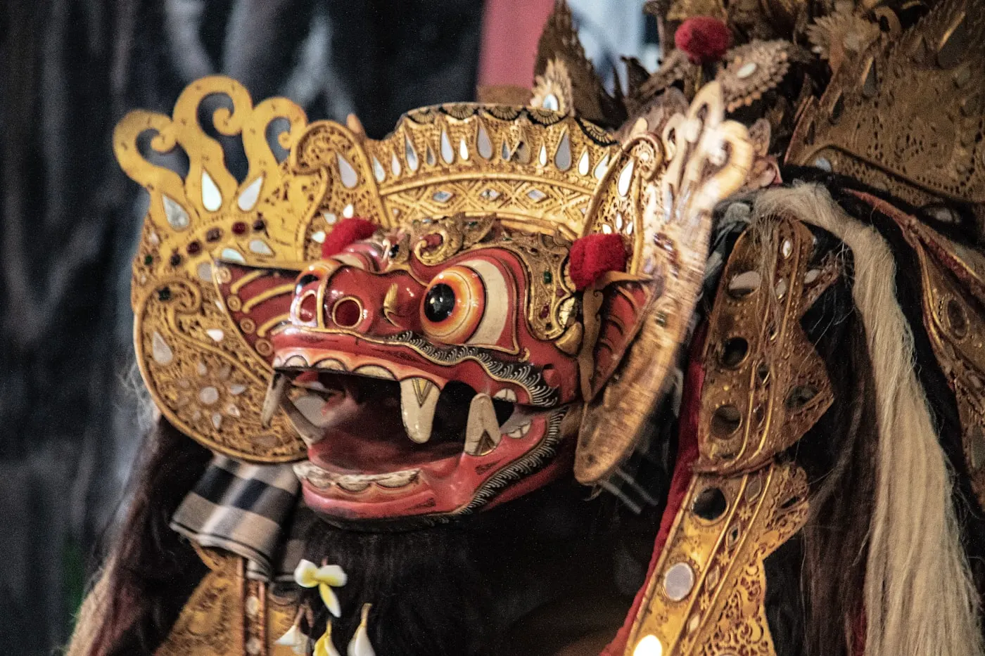 Close-up of a Barong Ket mask, red face with gold crown and mirrors