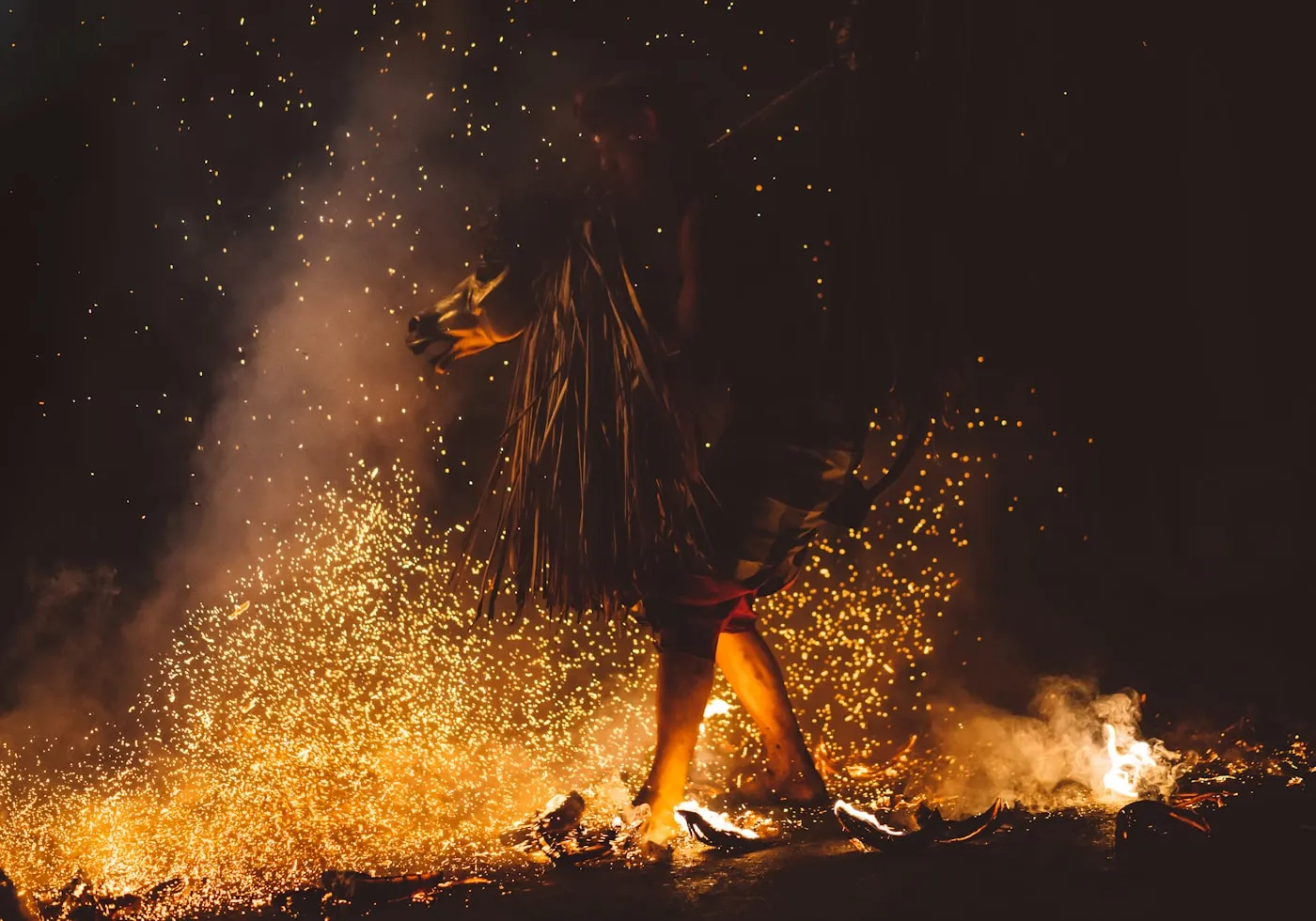 A performer walking through burning coconut husks