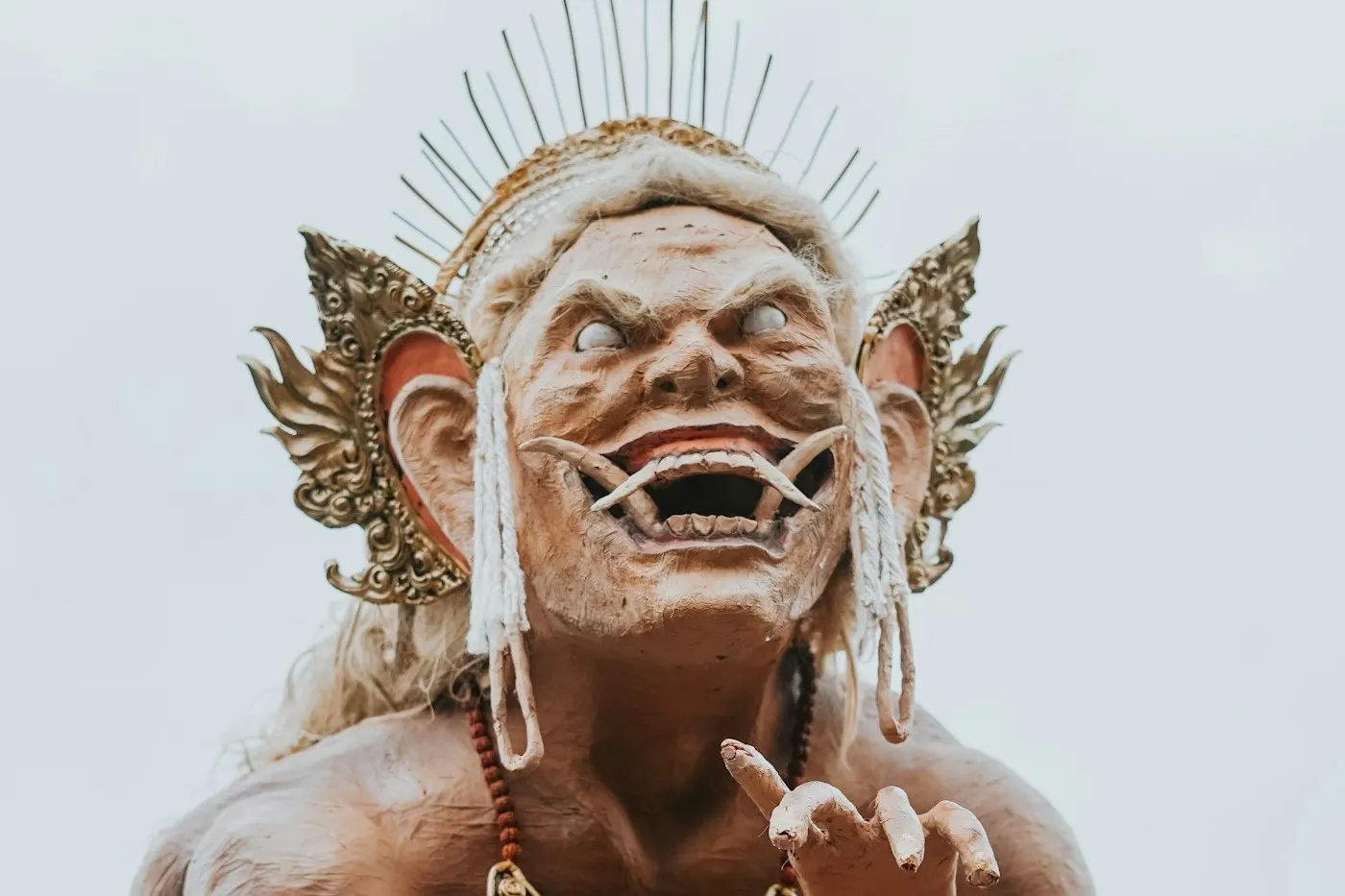 A towering ogoh-ogoh effigy raised above the street on the eve of Nyepi