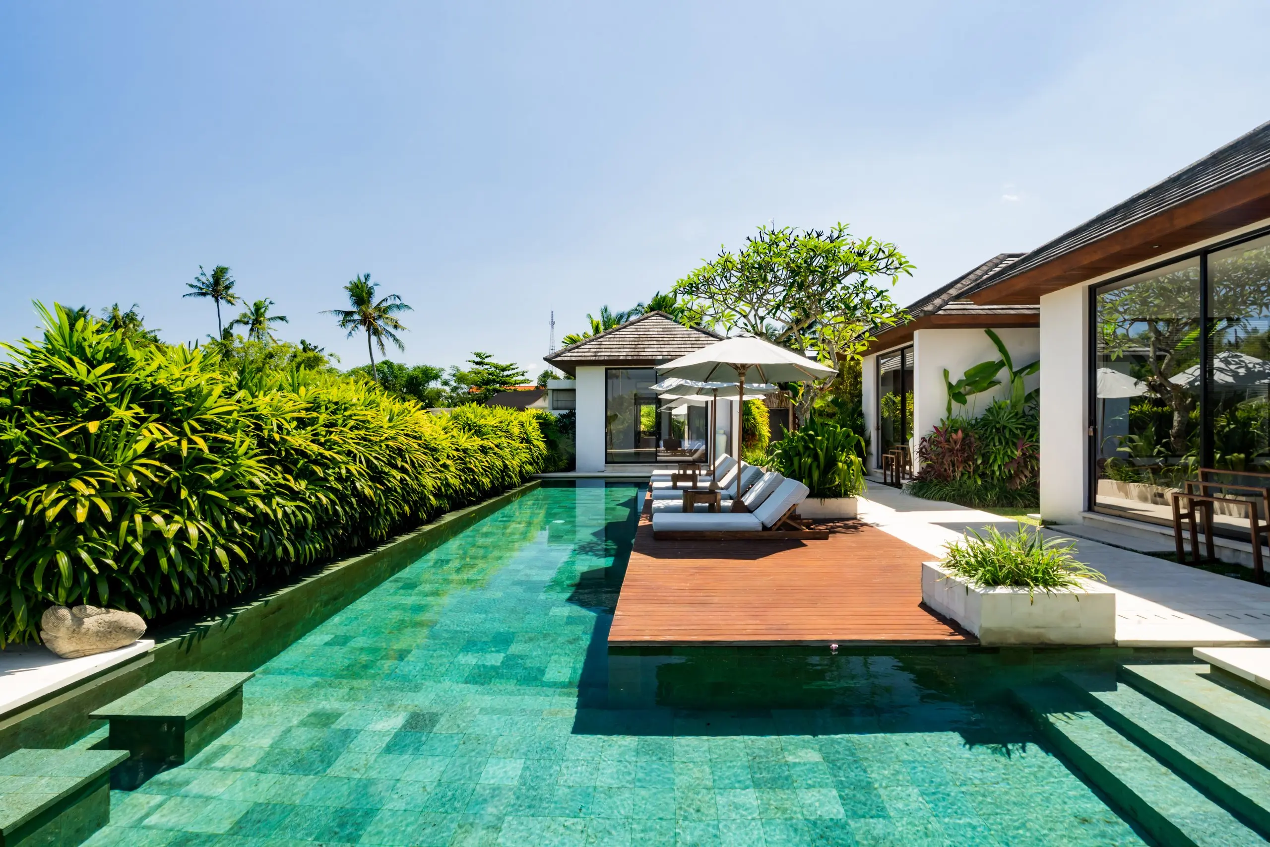 The full length of the pool, the sun deck and the living pavilion beyond